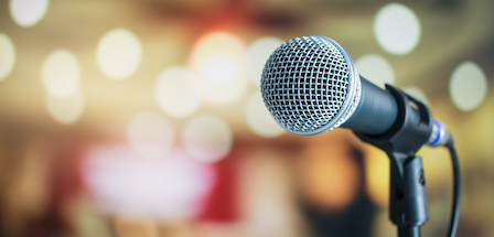 Microphone on abstract blurred of speech in seminar room or speaking conference hall light background