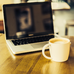 Computer on a desk with a coffee cup