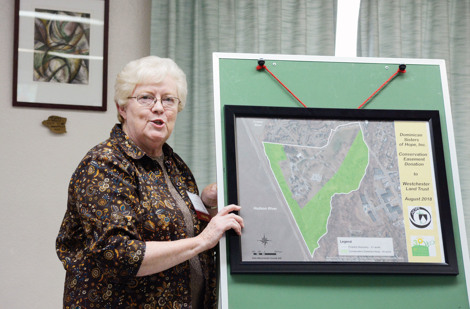 At the press conference, Sister Lorelle Elcock stands by a map of the property which shows which section of land will be preserved through the conservation easement.