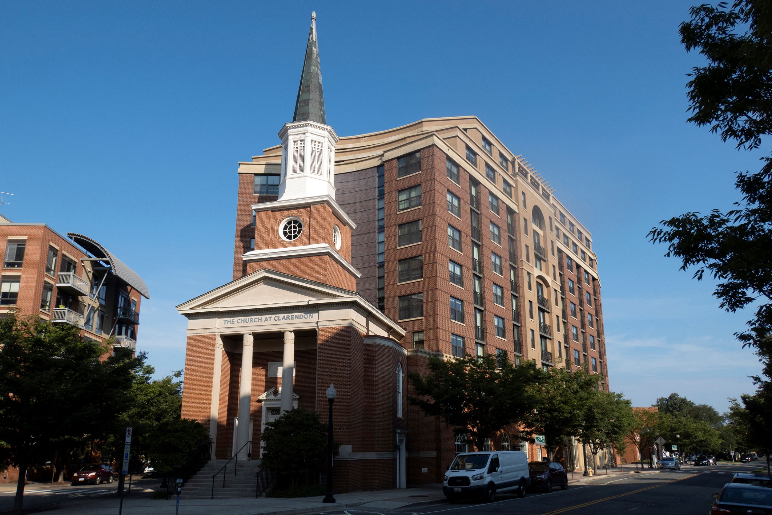Image of the repurposed church space - affordable housing makes up the majority of the building, and a traditional church front and steeple make up the front of the building