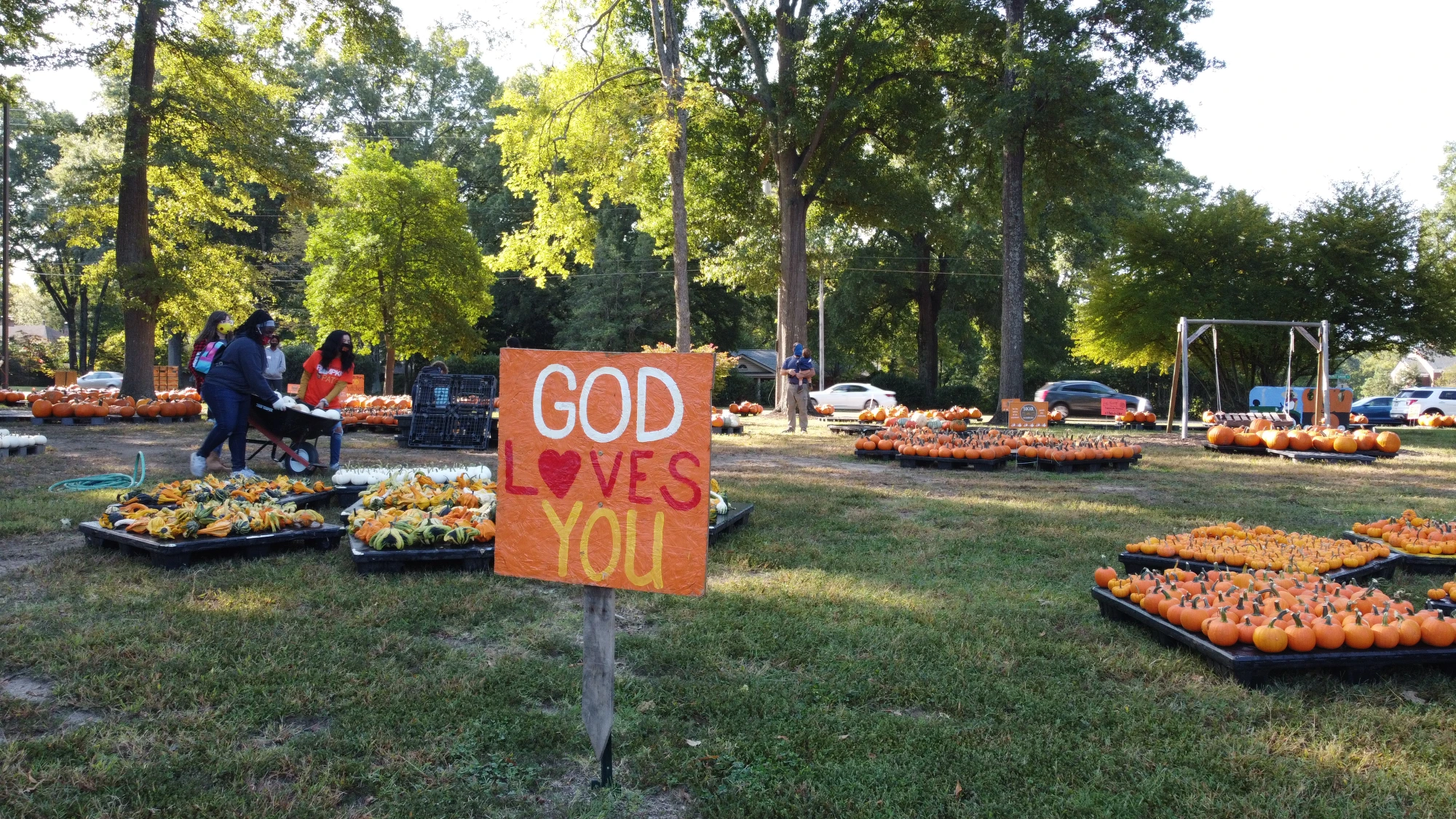 Photo of a pumpkin patch with a sign that reads: "God loves you"