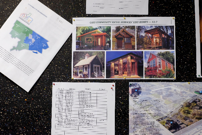 Photo of a cork board with photos of different tiny house styles.