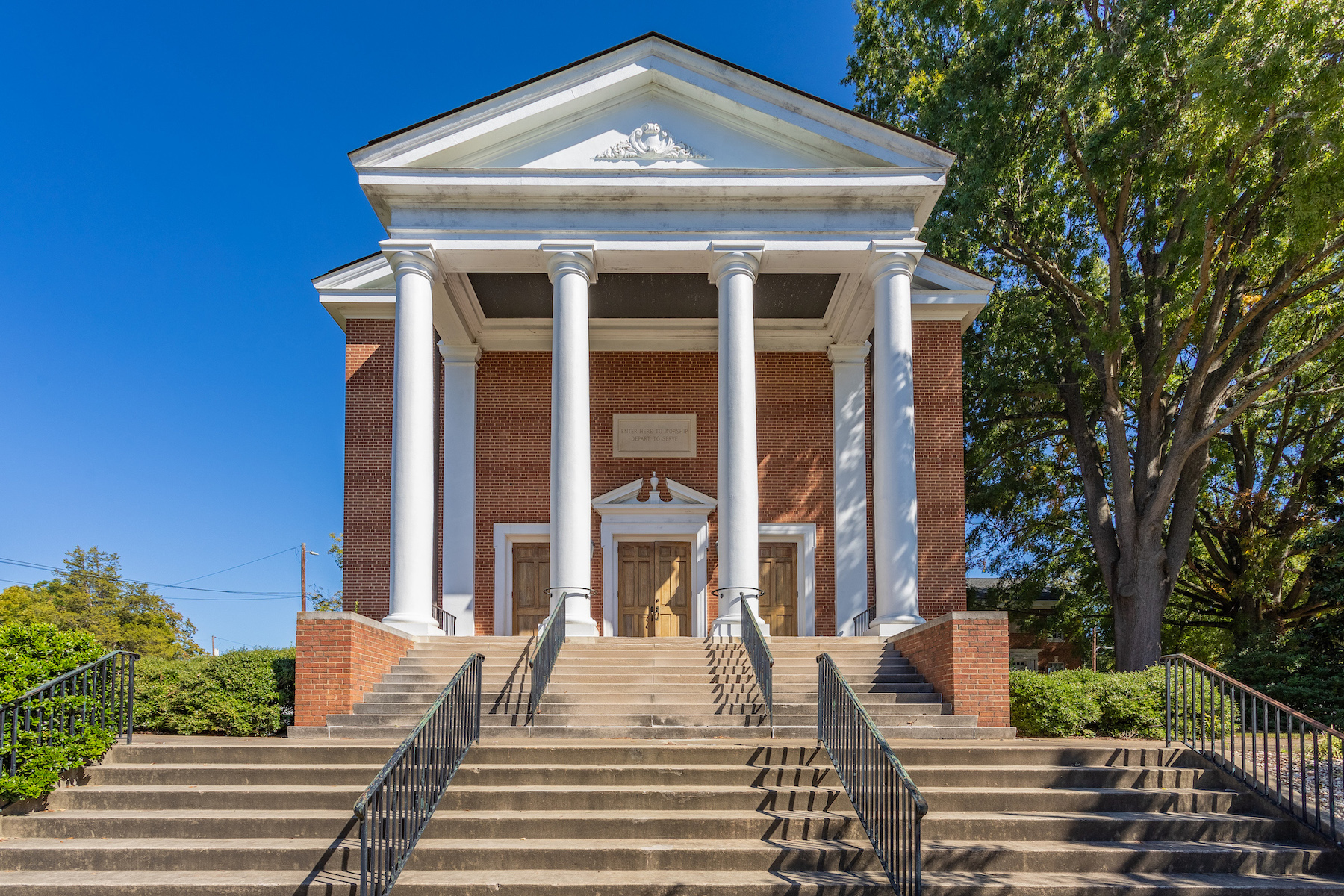 Photo of the front of Davis Street UMC, a large brick church with four white columns in the front.