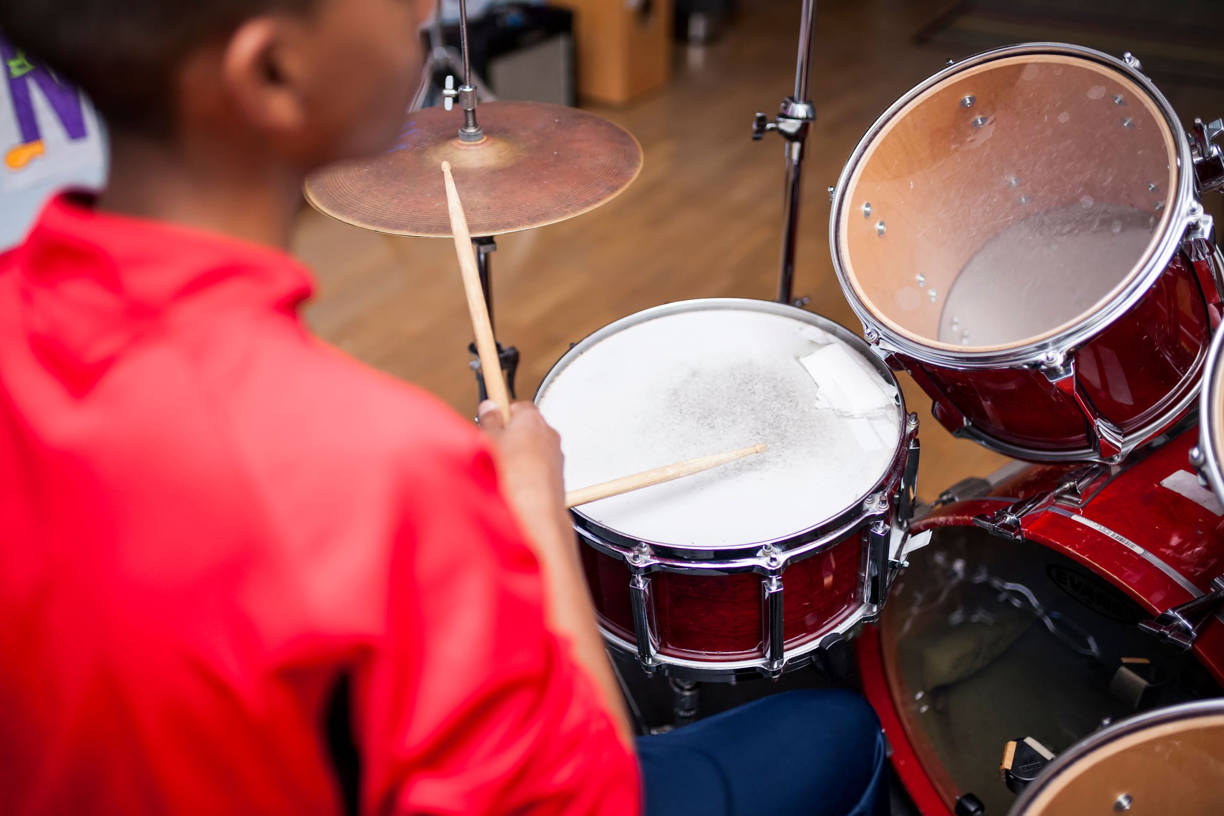Photo of a Black boy playing the drums.