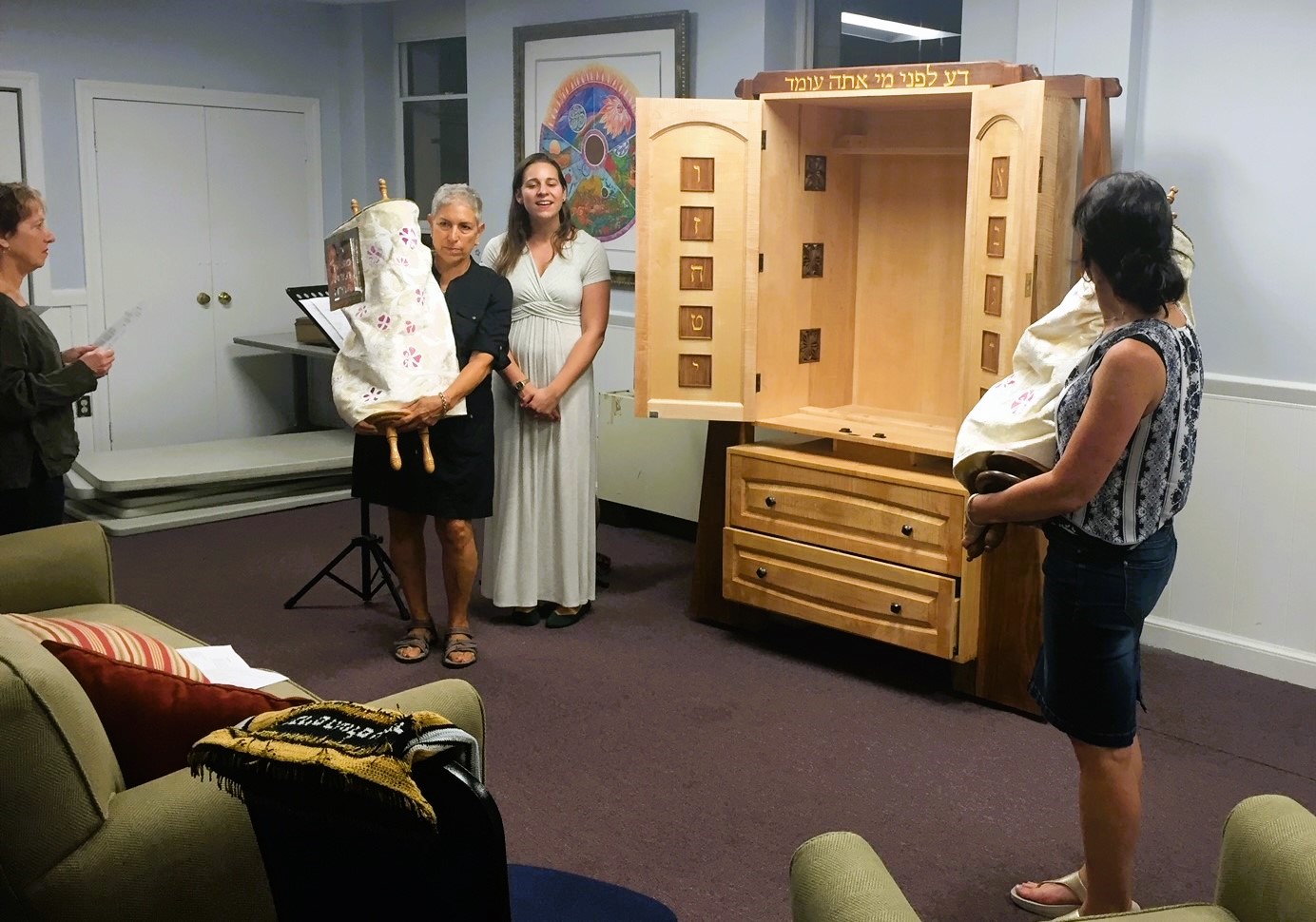 Hill Havurah worshipers hold Torahs from the porable ark during a religious service in the Shalom Room at Lutheran Church of the Reformation.