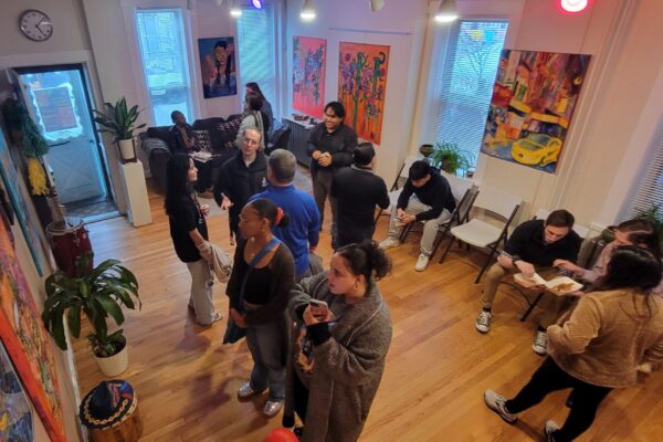 Visitors look at art and talk among themselves in a room featuring Latino art.