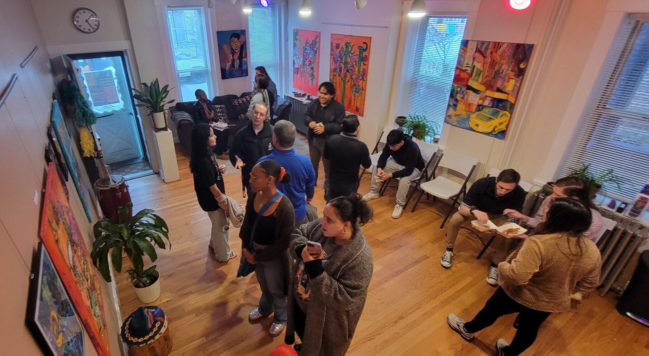 Visitors look at art and talk among themselves in a room featuring Latino art.