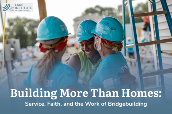 Three Habitat for Humanity workers hugging with hard hat ons