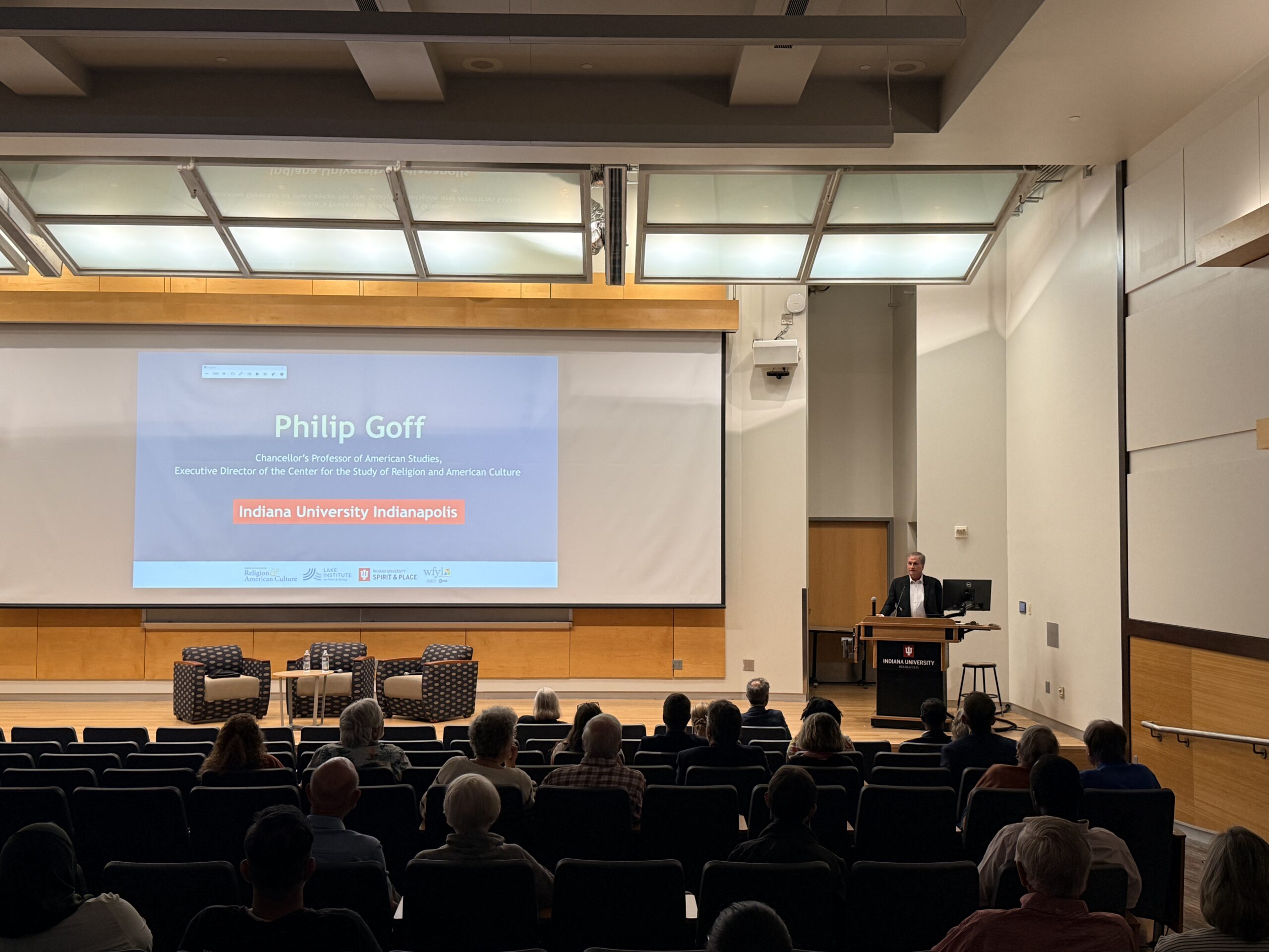 Philip Goff standing on stage presenting